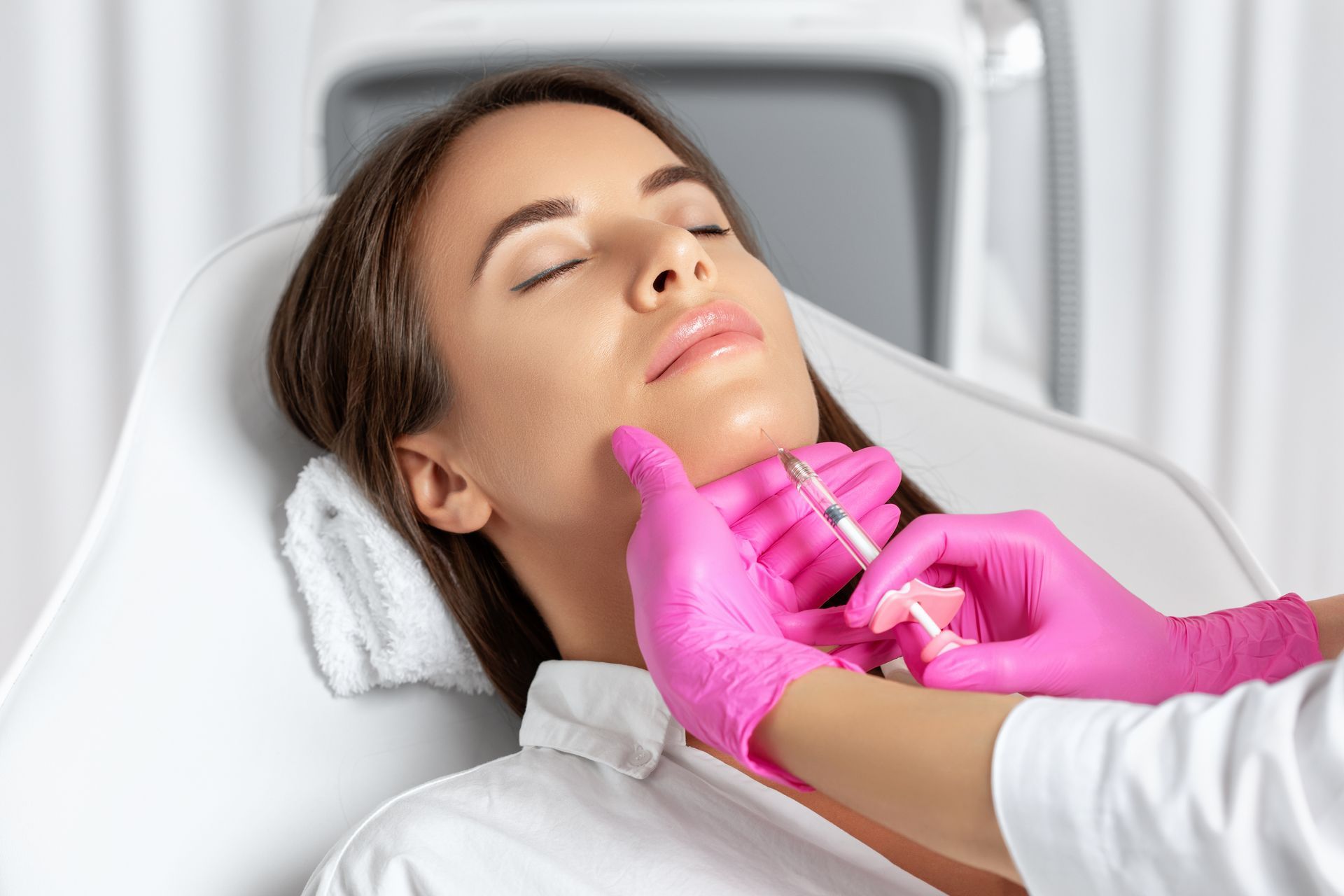 A woman is getting a botox injection in her face.