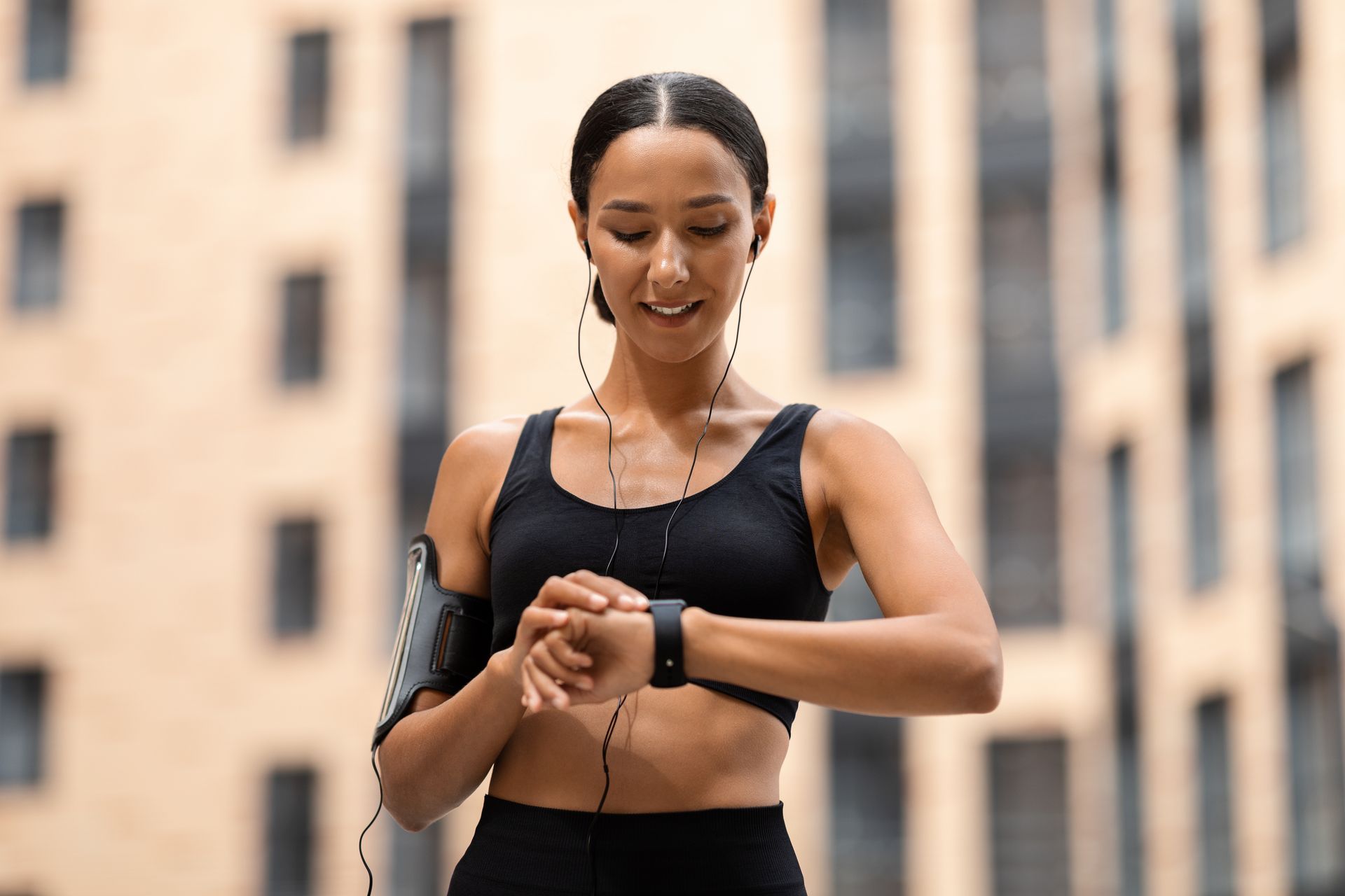 A woman is wearing headphones and a smart watch on her wrist.