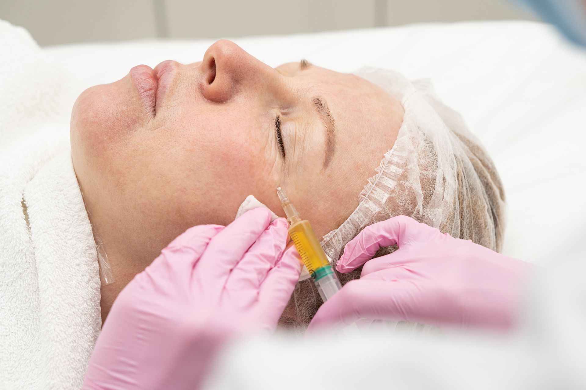 A woman is getting a botox injection in her face.