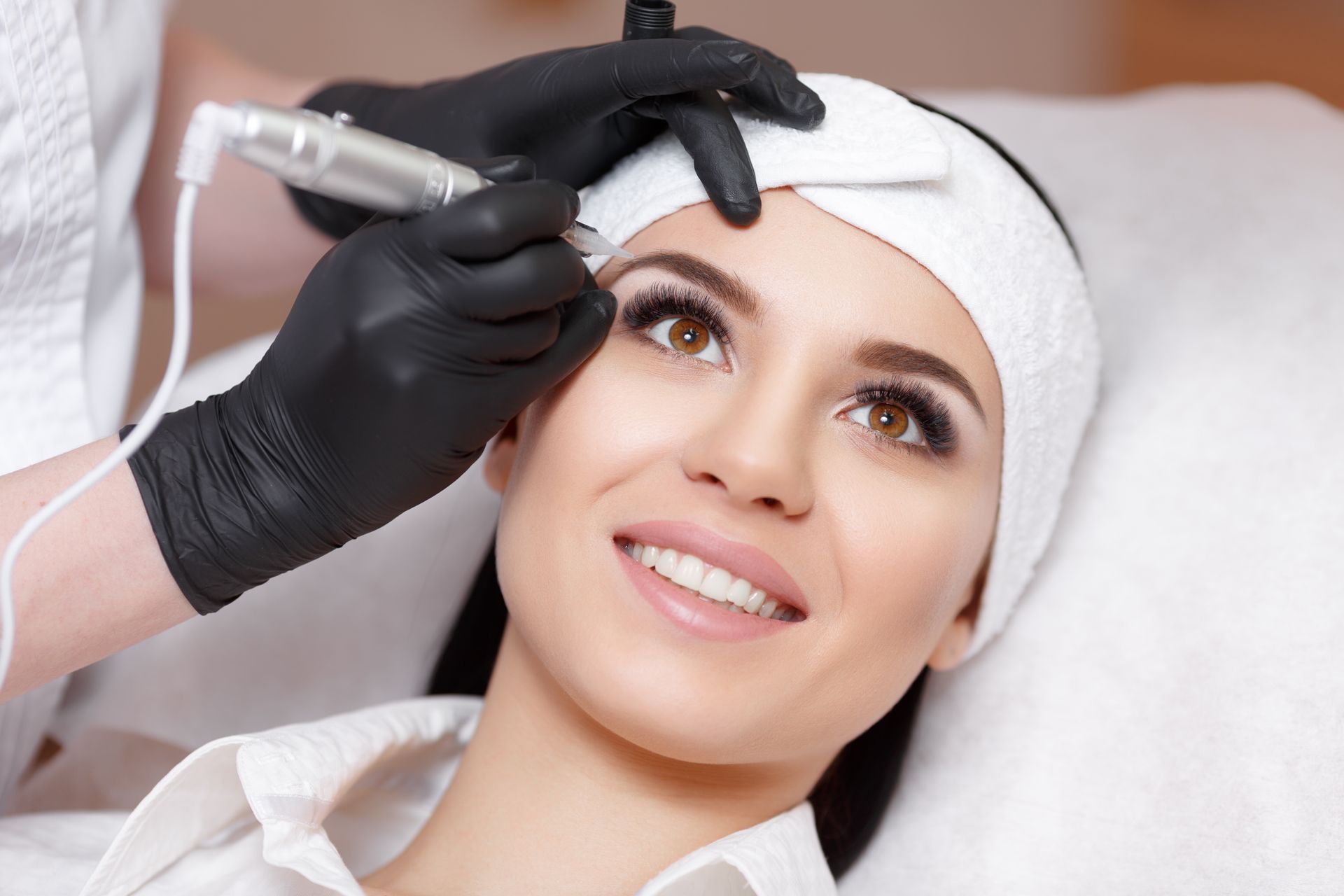 A woman is getting permanent makeup on her eyebrows.