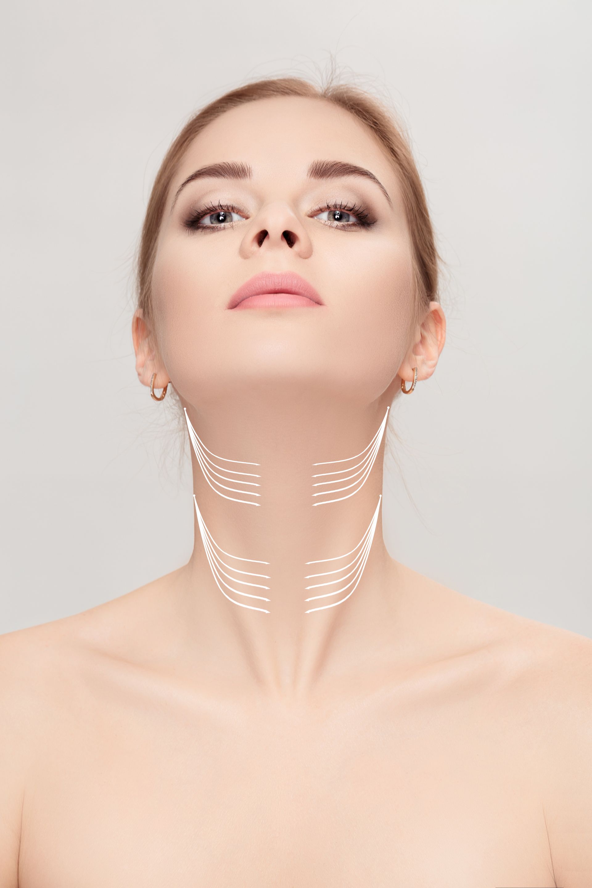 A woman is looking up at her neck with lines drawn on it.