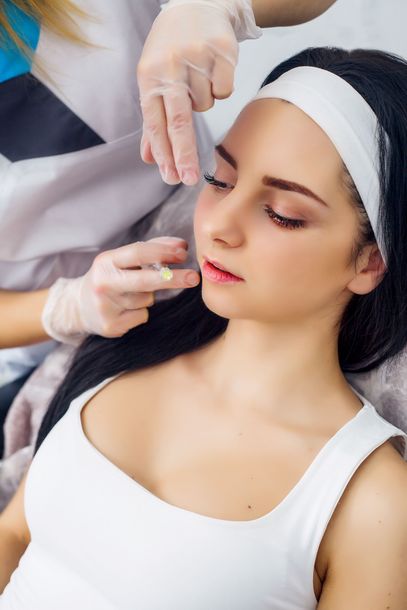 A woman is getting a facial treatment at a beauty salon.