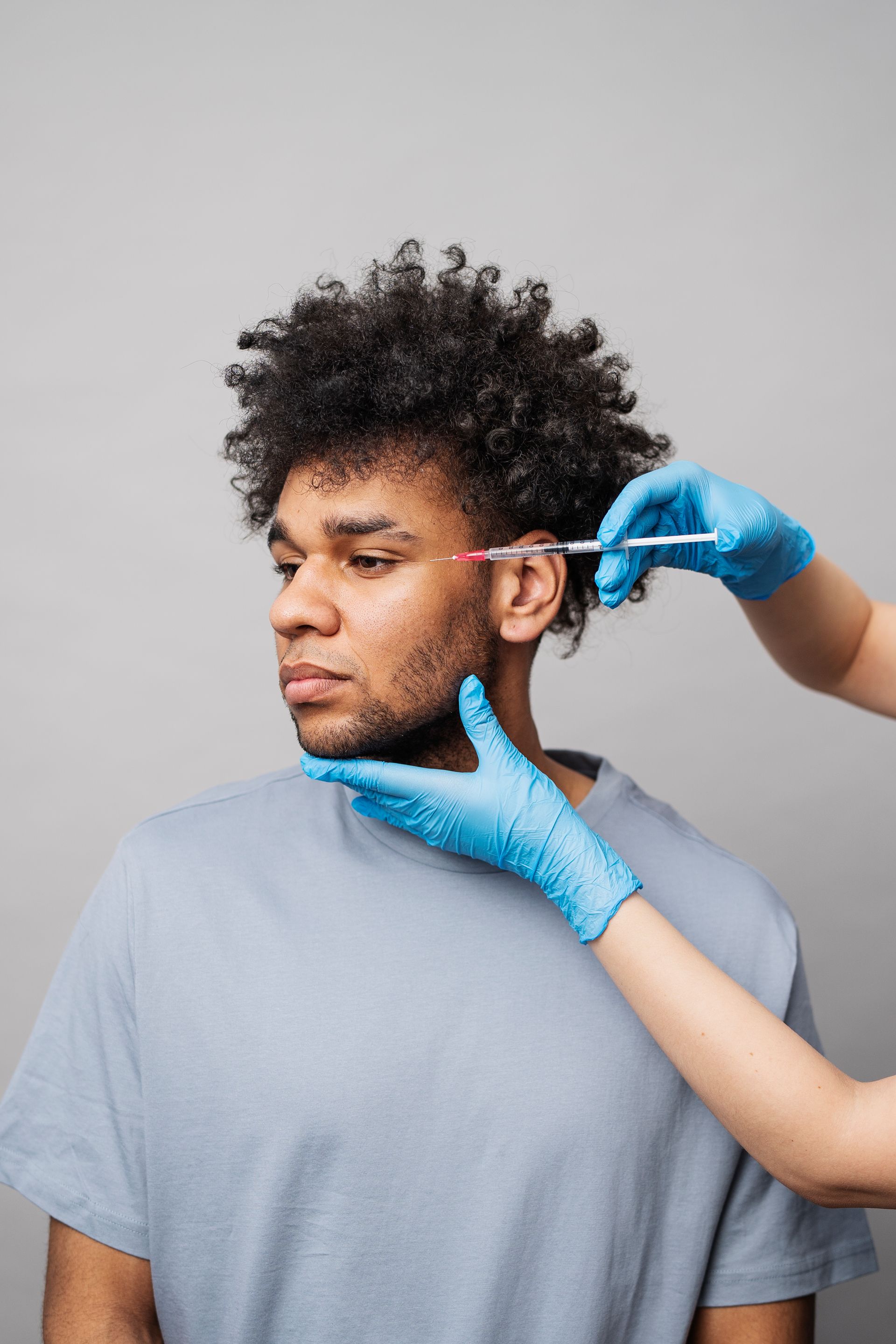 A man is getting an injection in his ear.