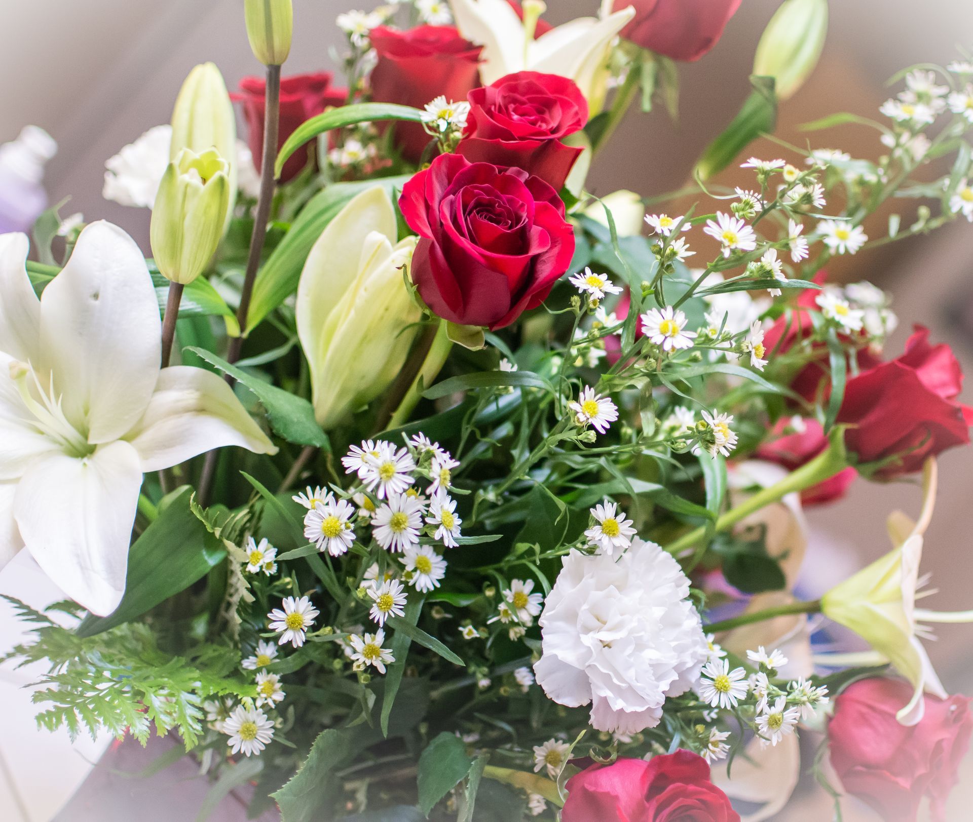 Un mazzo di fiori con rose rosse e margherite bianche