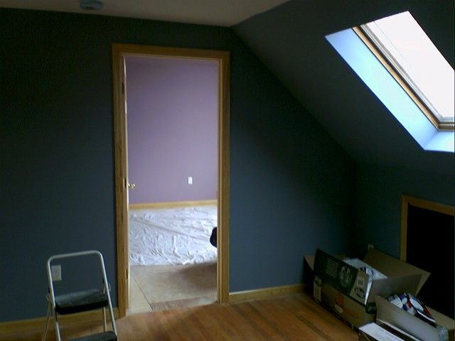 Interior room with dark blue walls, a door to a purple room, and a skylight.