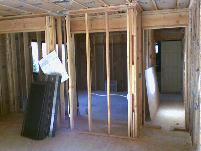 Interior house framing under construction; multiple doorways, light wood, unfinished.