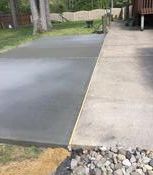 Freshly poured gray concrete beside weathered concrete path.