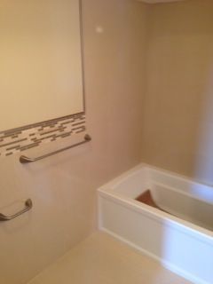 Bathroom with white tub, light walls, towel bars.