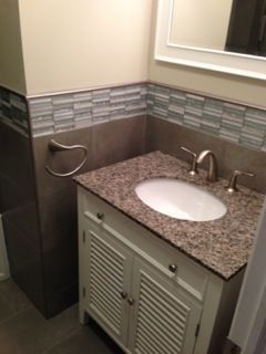 Small bathroom with a white vanity, granite countertop, and tile backsplash.