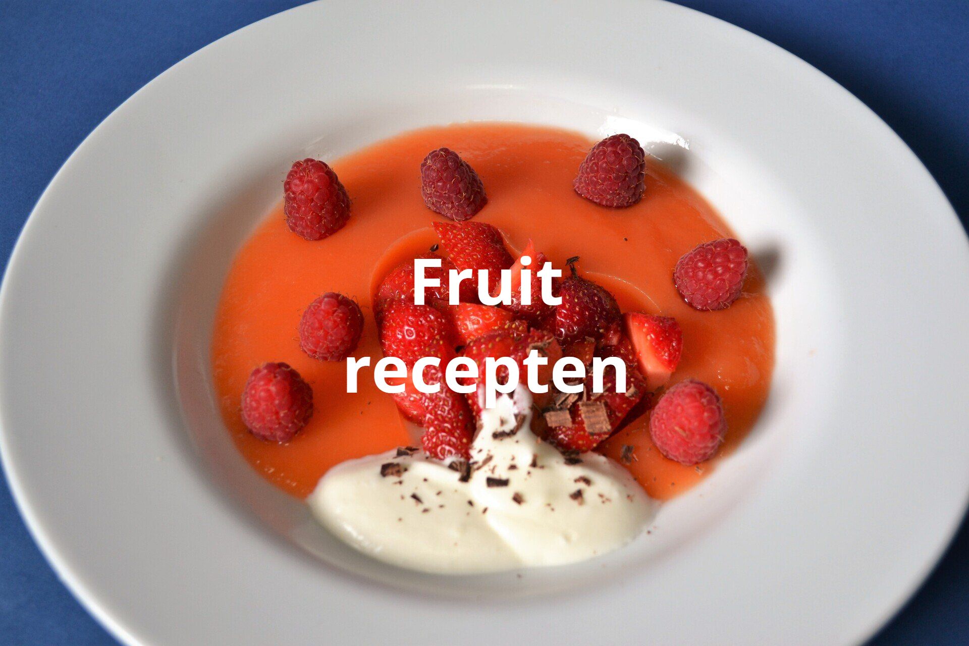 Een wit bord met aardbeien en frambozen en de tekst fruitrecept erop