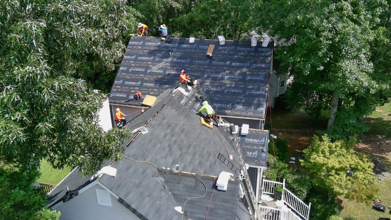 A person is pointing at a hole in a roof tile.