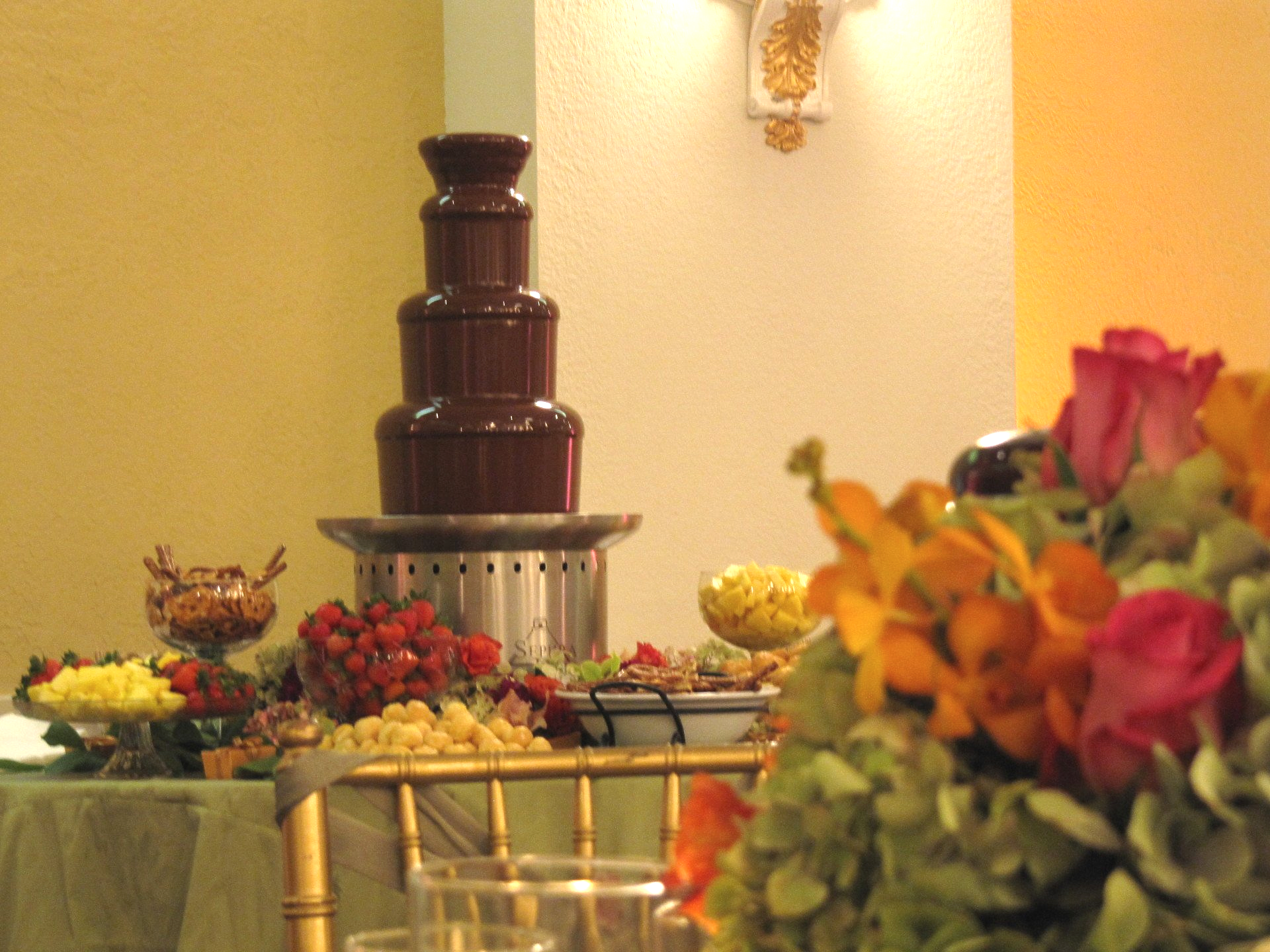 A table with a chocolate fountain and flowers on it