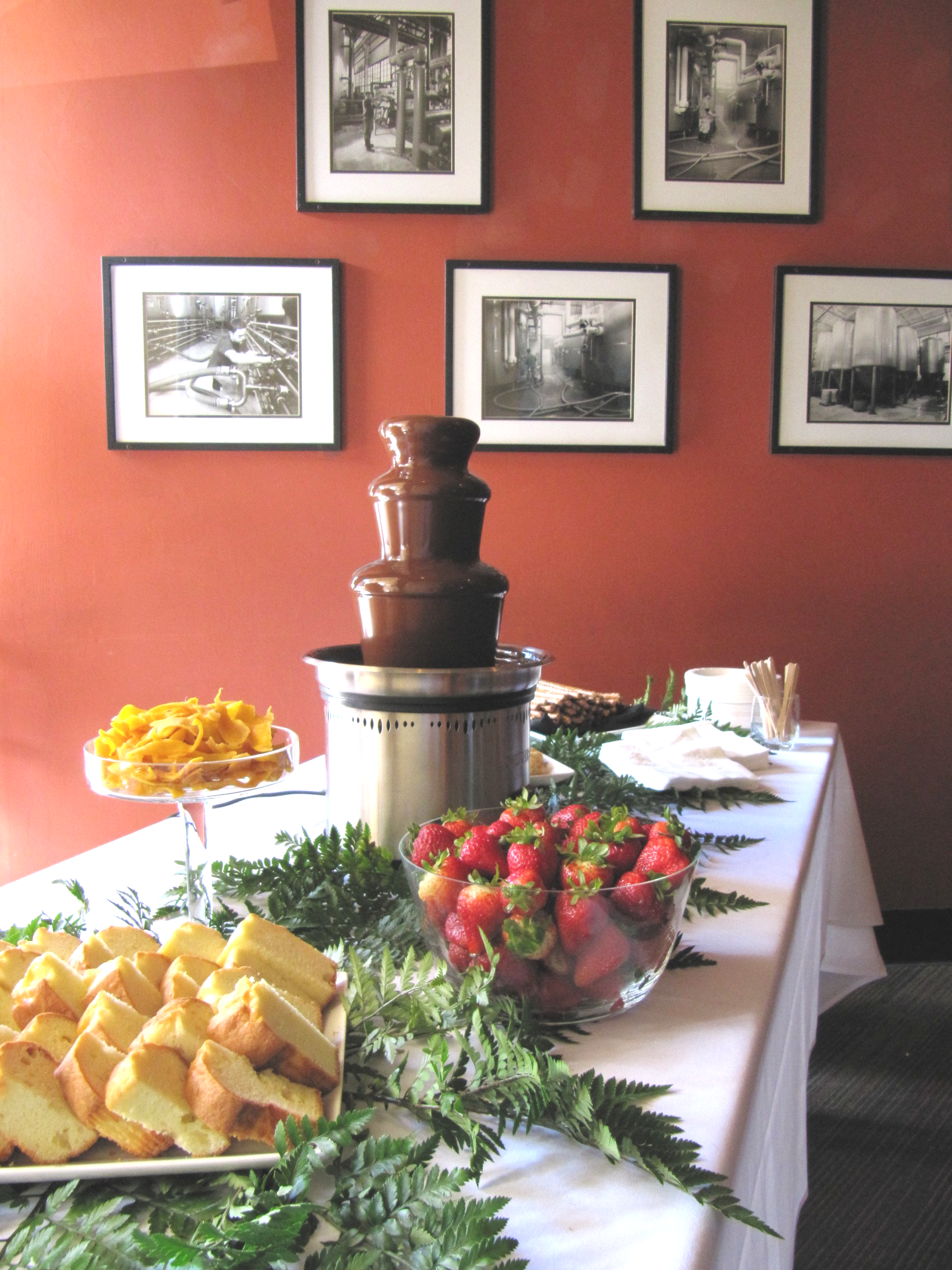 A table with a chocolate fountain and strawberries on it