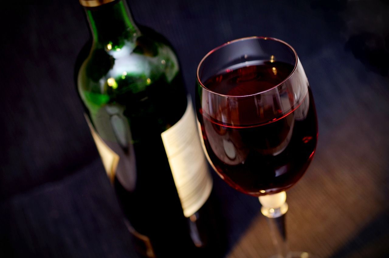 a bottle of wine sits next to a glass of wine