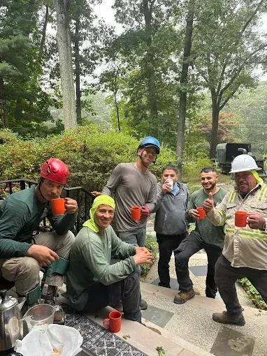 A group of men are sitting on a porch drinking coffee.