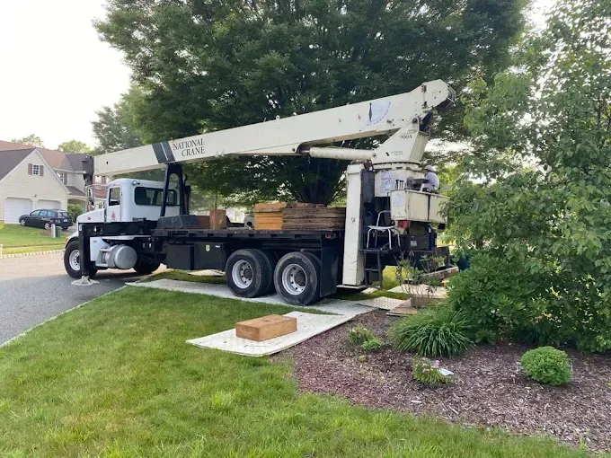 A truck with a crane on the back of it is parked on the side of the road.