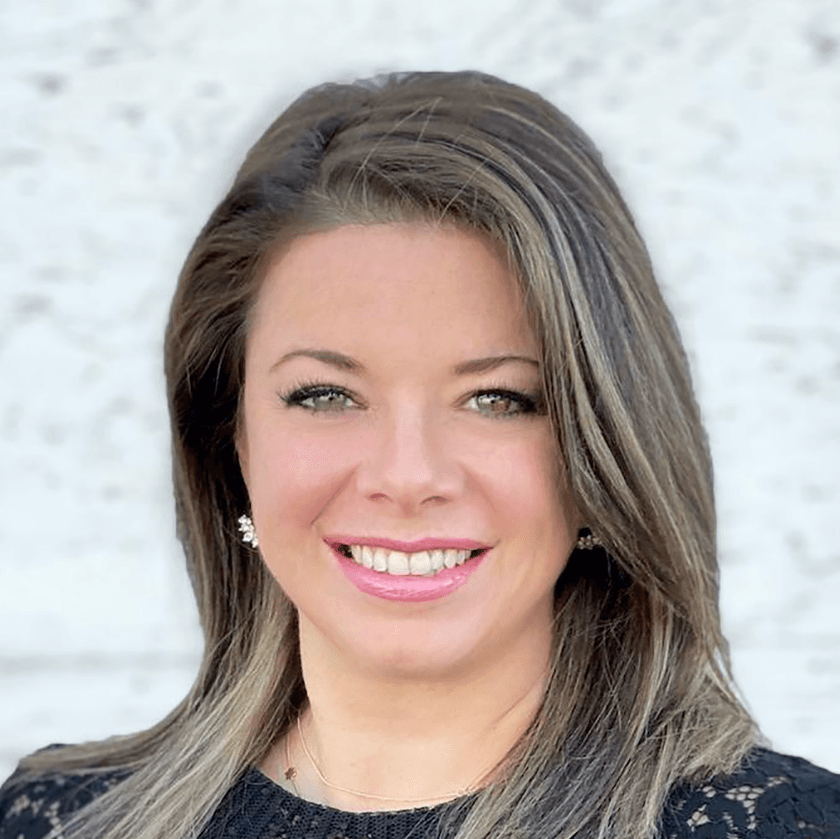A woman with long brown hair is smiling for the camera.