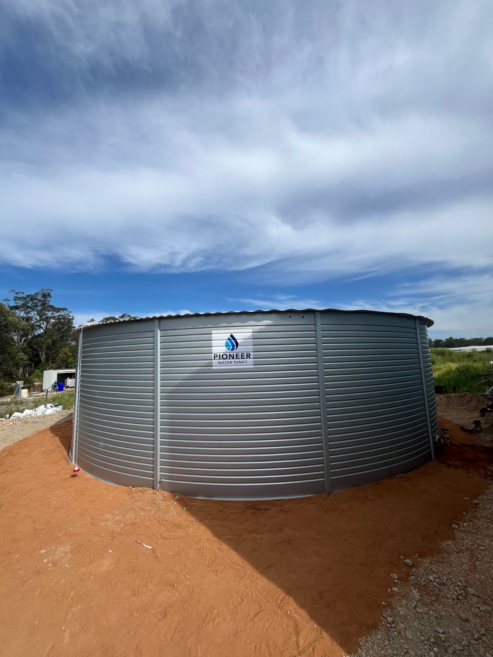 A Large Metal Tank is Sitting on Top of a Dirt Field — Elite Water In Koonorigan, NSW