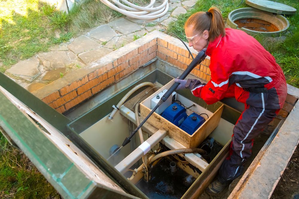 A Woman is Cleaning a Septic Tank With a Vacuum Cleaner — Elite Water In Koonorigan, NSW