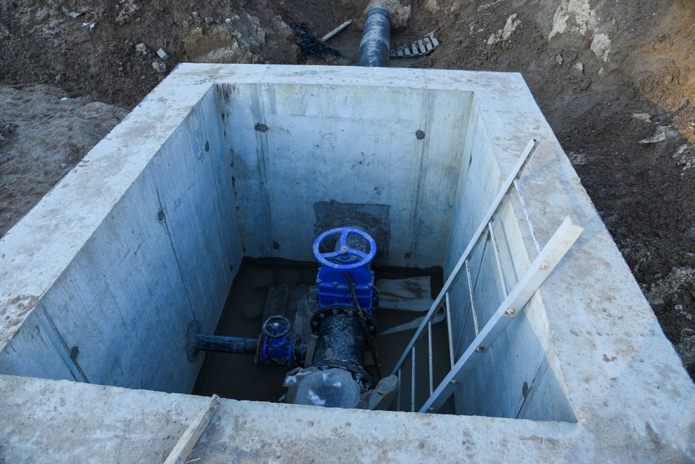 A Blue Valve is in a Concrete Hole With a Ladder Leading to It — Elite Water In Lismore, NSW
