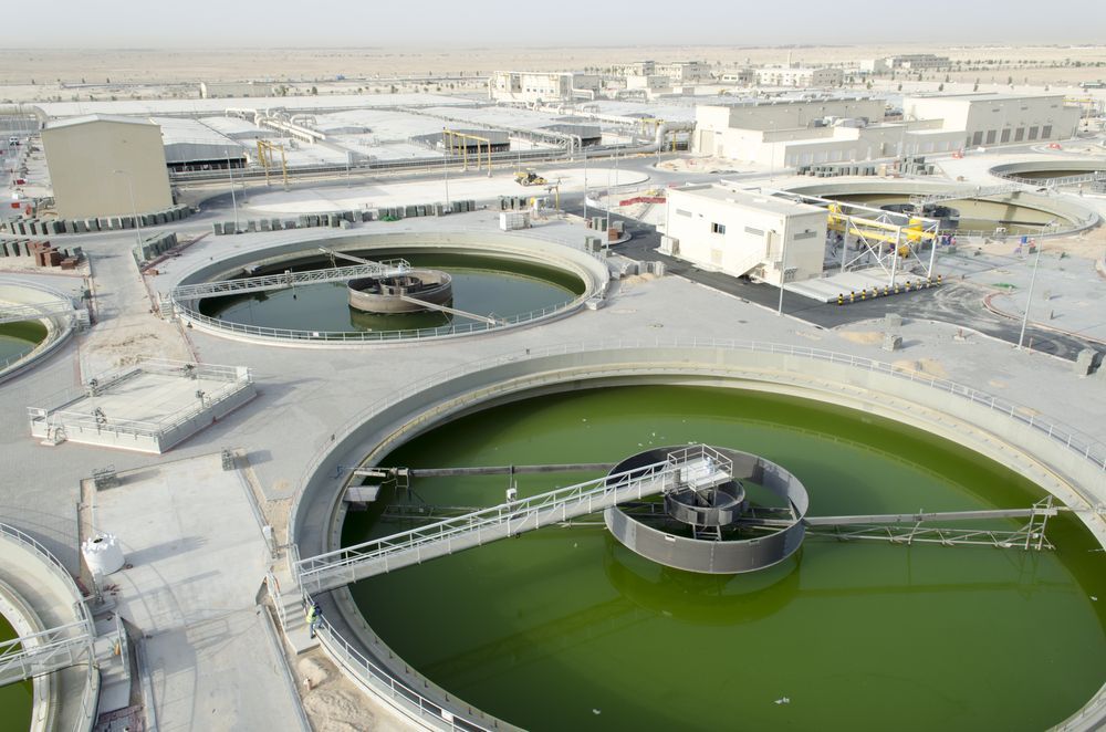 An aerial view of a water treatment plant with a lot of green water.