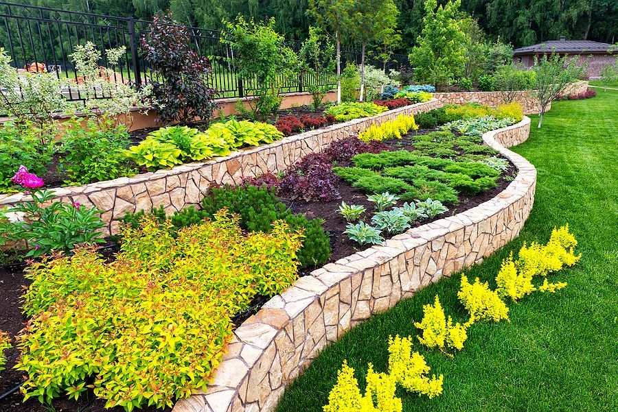 Professional landscaping with stone walls and perennials