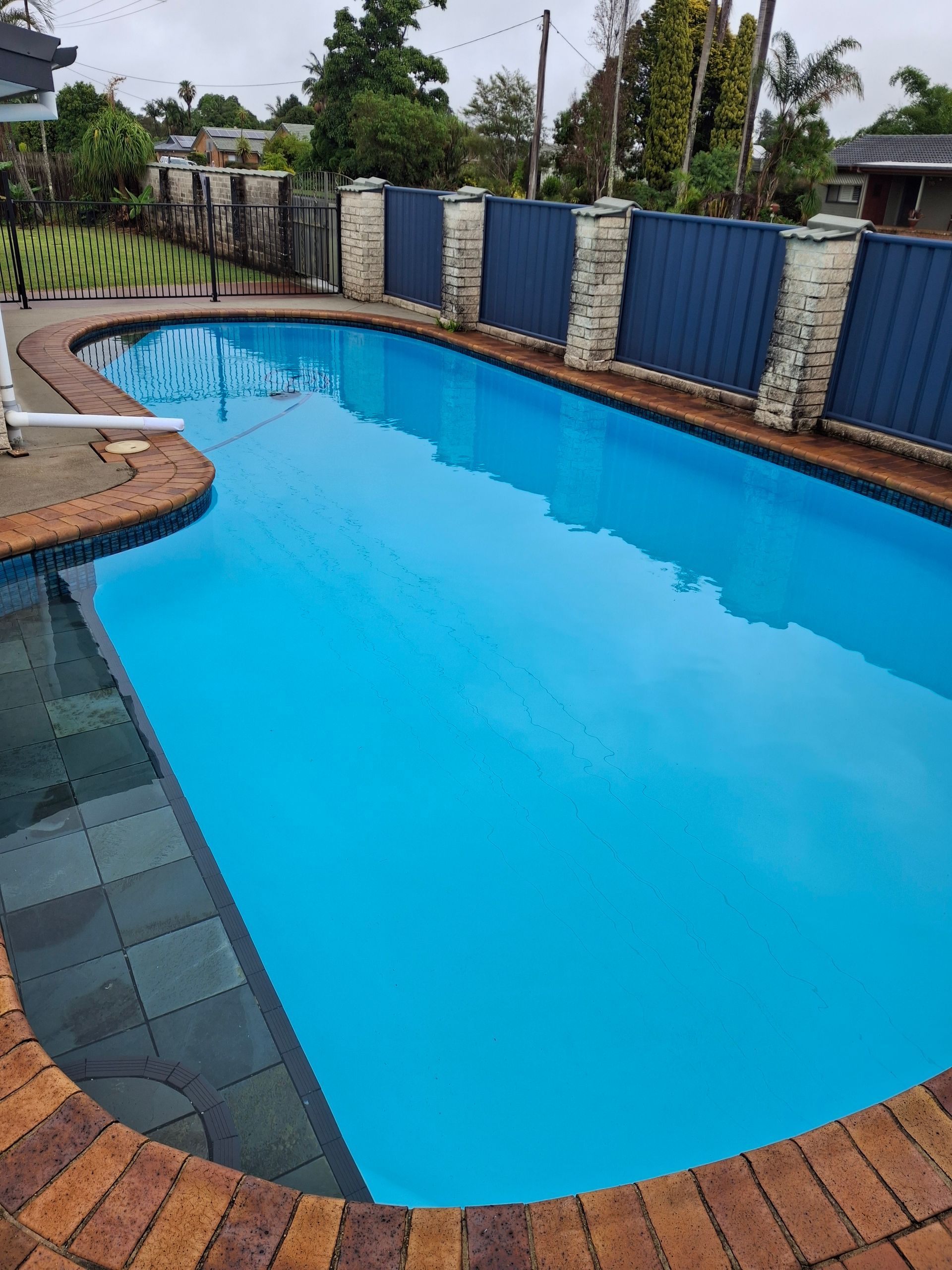 White Van Parked on Grass With a Man Standing Next to It — Ballina Leak Detection & Swimming Pool Repairs in Ballina, NSW