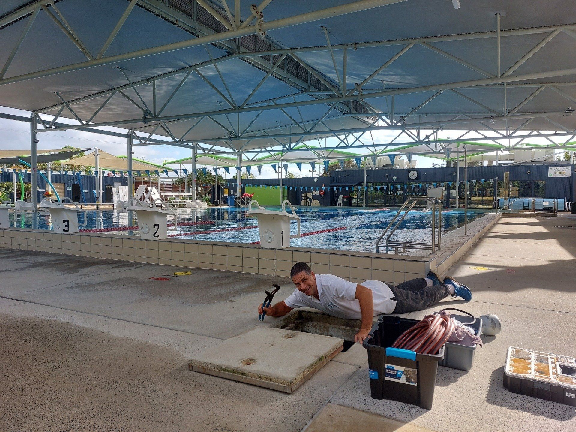 Man Working on Poolside Concrete Near a Swimming Pool — Ballina Leak Detection & Swimming Pool Repairs in Ballina, NSW