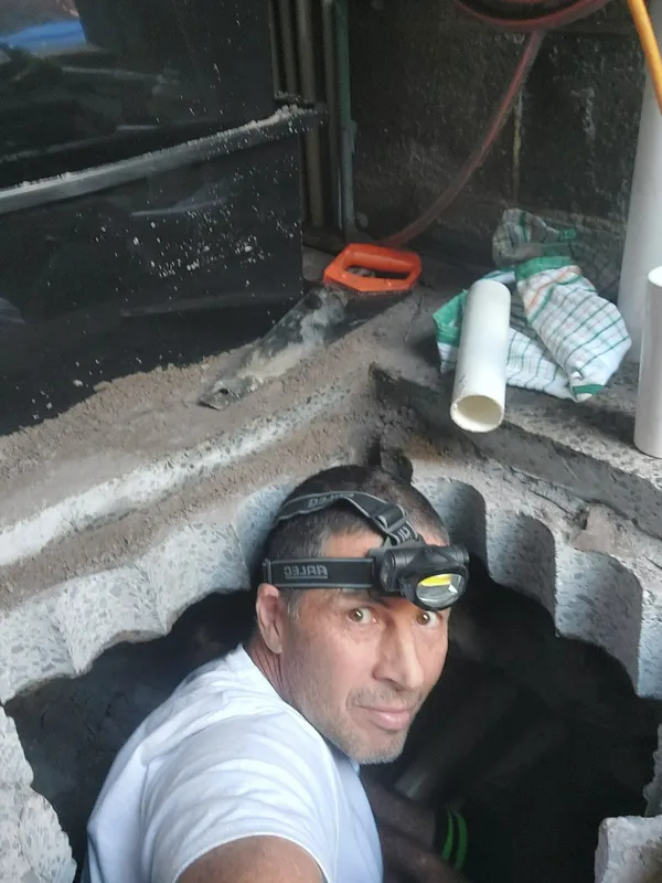 Man in Headlamp Looks Out of a Hole in a Gray Wall — Ballina Leak Detection & Swimming Pool Repairs in Ballina, NSW