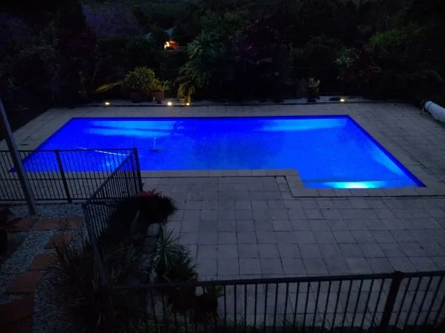 Blue-lit Pool at Night Surrounded by a Paved Patio — Ballina Leak Detection & Swimming Pool Repairs in Ballina, NSW