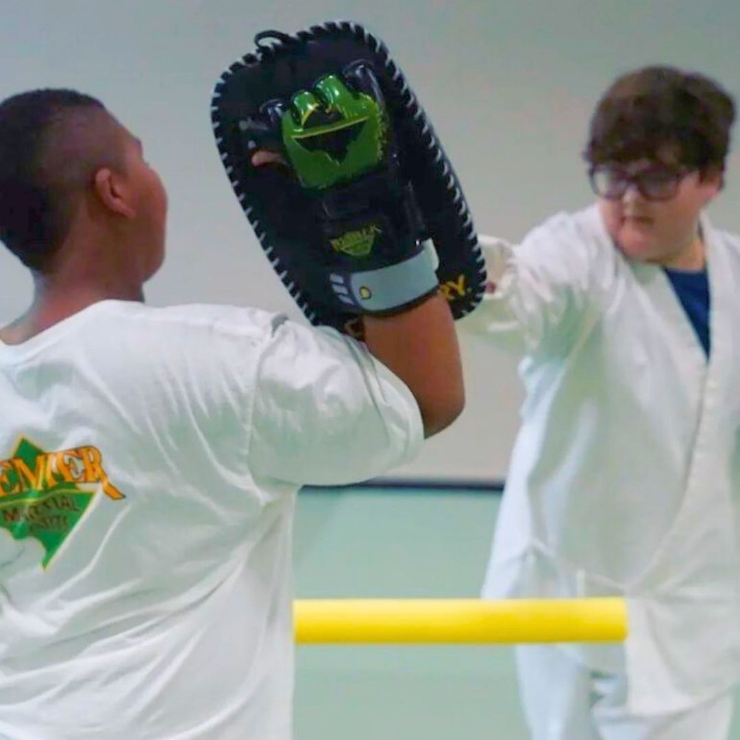 A boy and a girl are practicing taekwondo together.