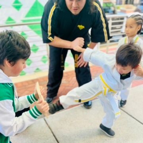 A young girl is practicing taekwondo in a gym.
