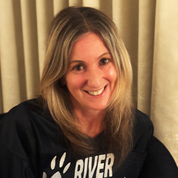 Arden Glogau wearing a river shirt smiles for the camera