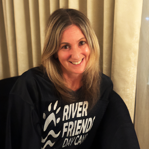 A woman is wearing a river friend day camp shirt