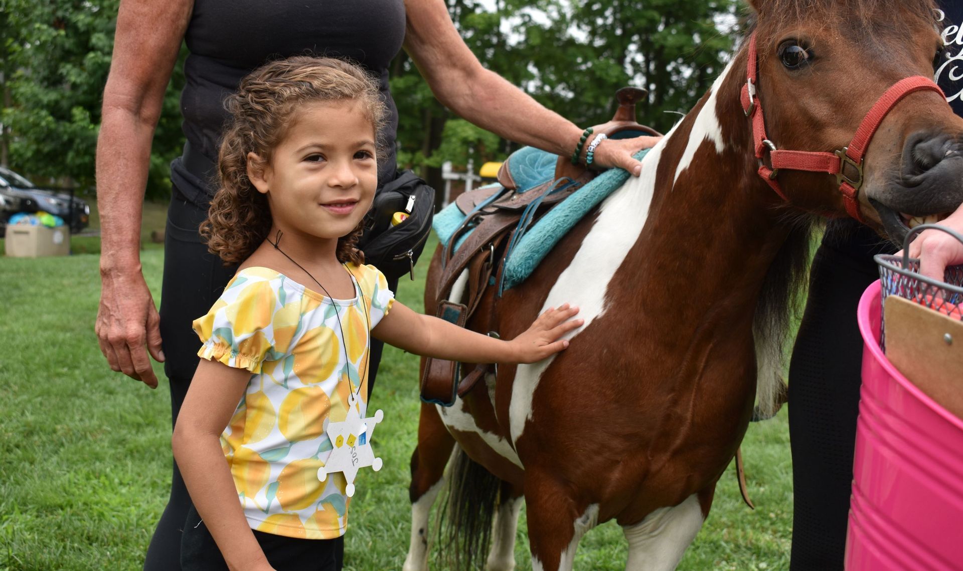 A little girl is petting a brown and white horse.