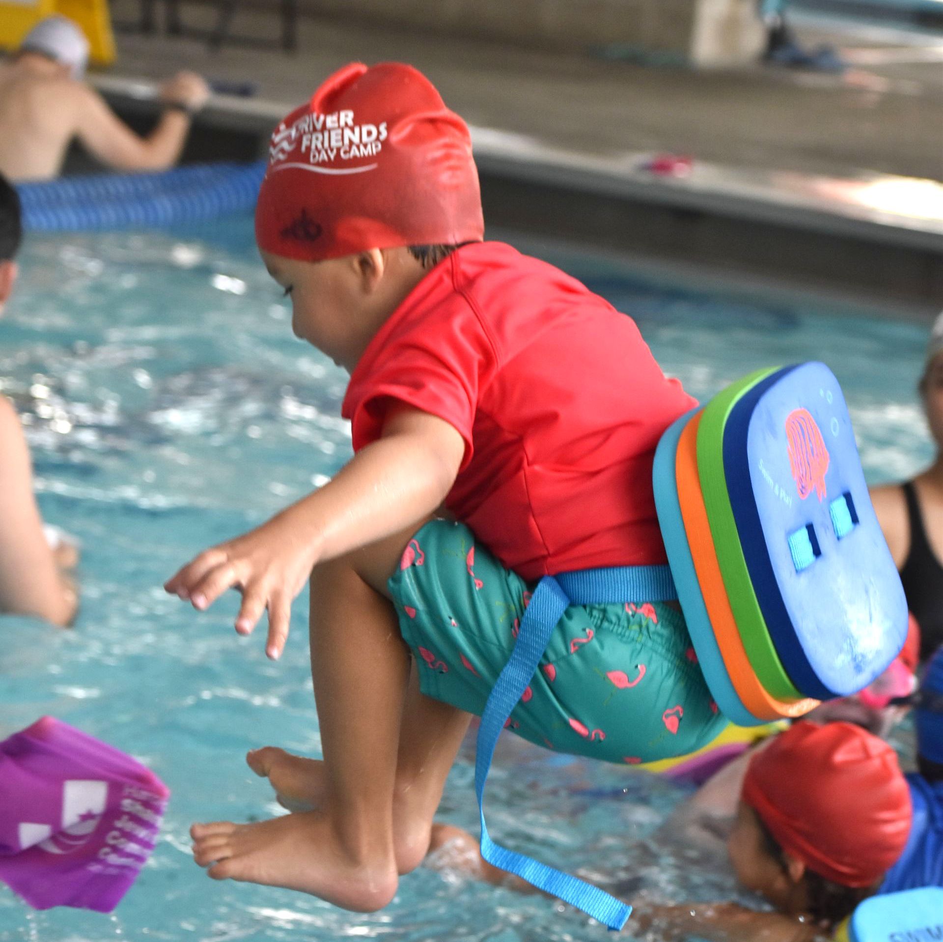 A child wearing a red swim cap that says friends on it