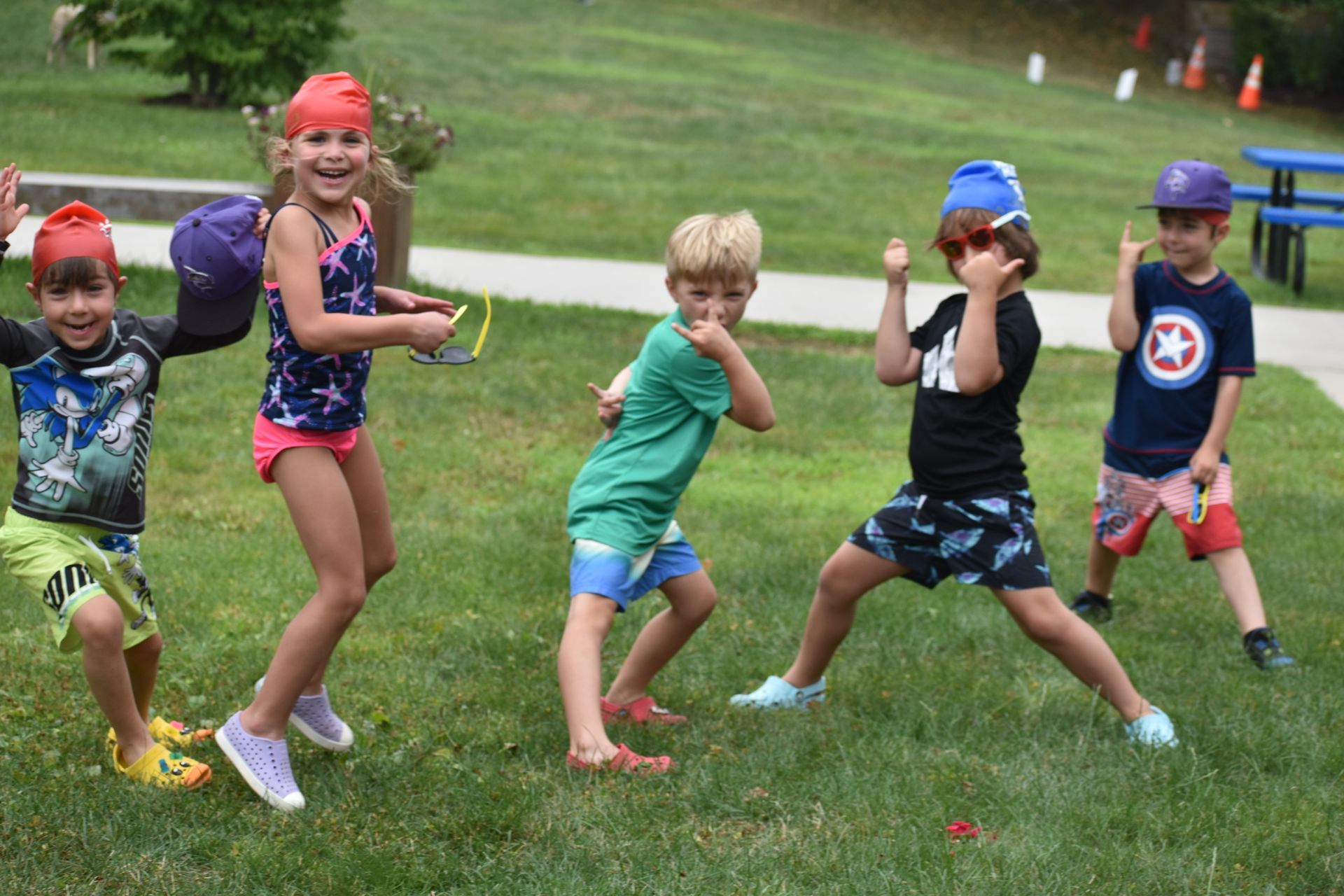 A group of children are standing in a grassy field.