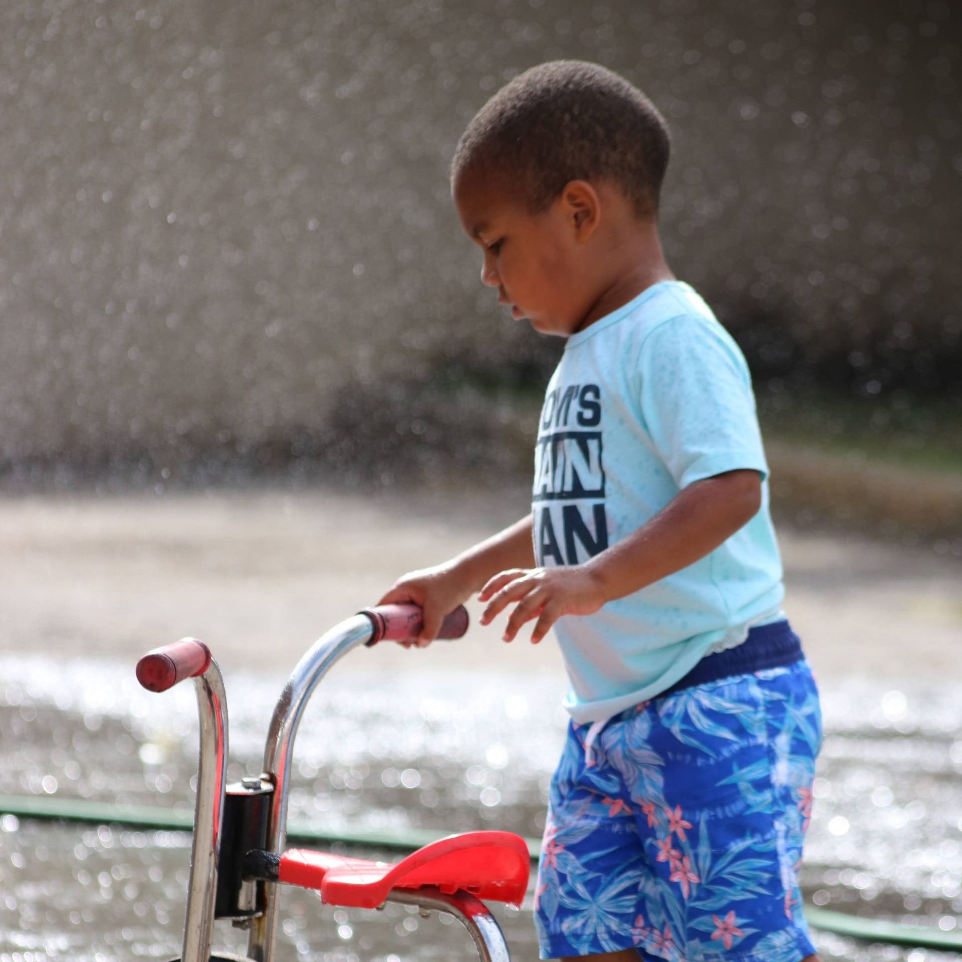 A young boy riding a tricycle
