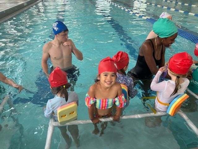A group of children are swimming in a pool.