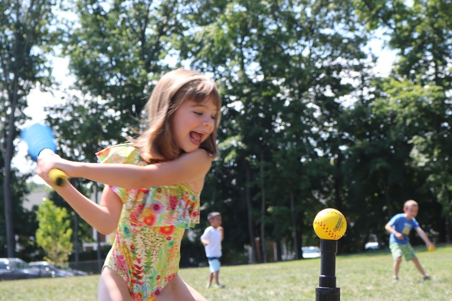 A little girl is swinging a tennis racket at a tennis ball