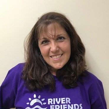 Melanie Freidman a purple river friends shirt is smiling.