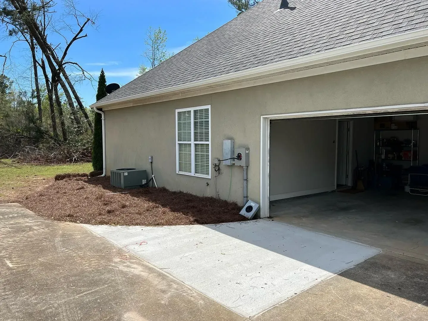 A house with a garage and a driveway in front of it.