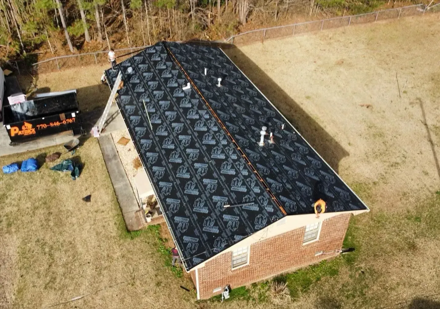 An aerial view of a house with a new roof being installed.