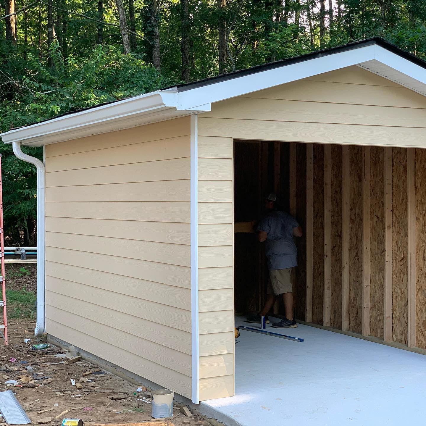 A man is working on a garage that is being built