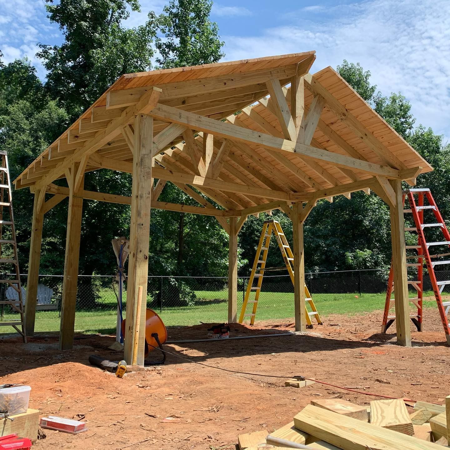 A wooden structure is being built in a dirt field.