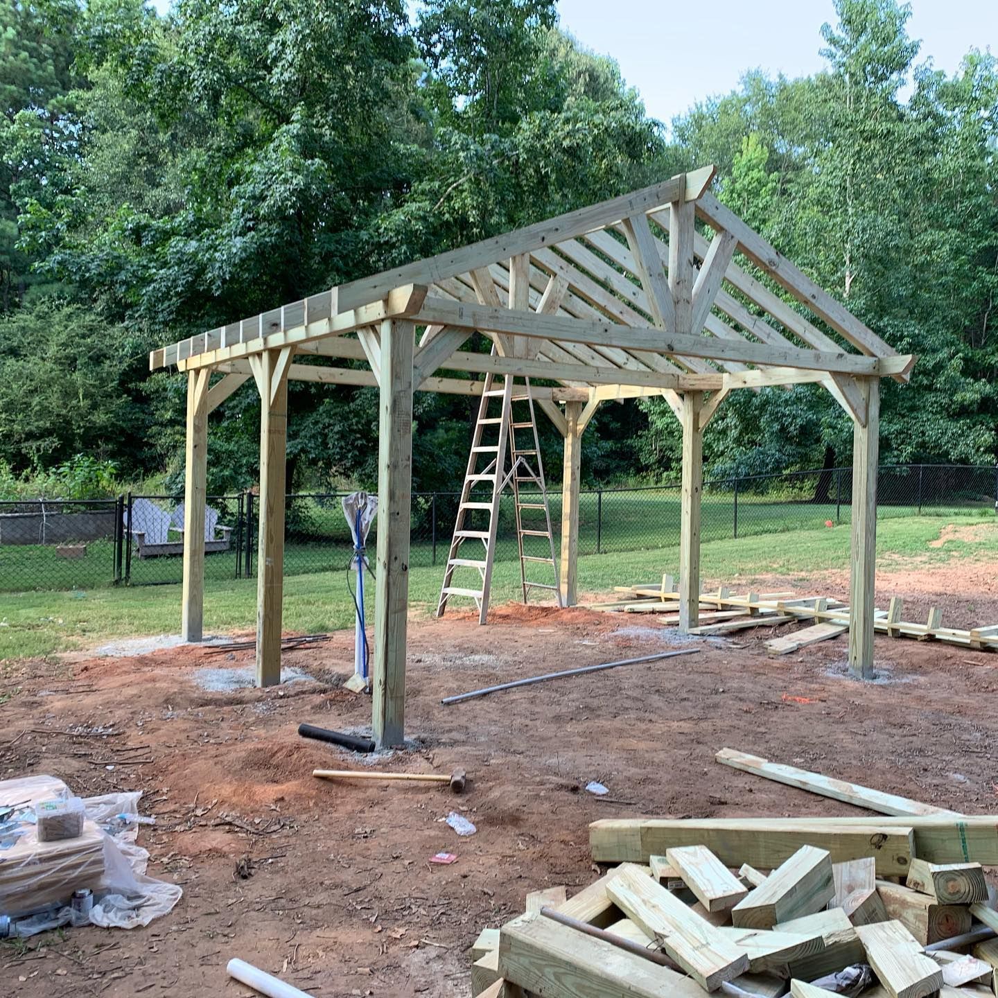 A wooden structure is being built in the middle of a dirt field.