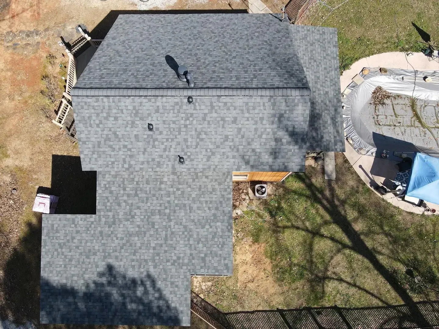 An aerial view of a house with a roof and a pool.