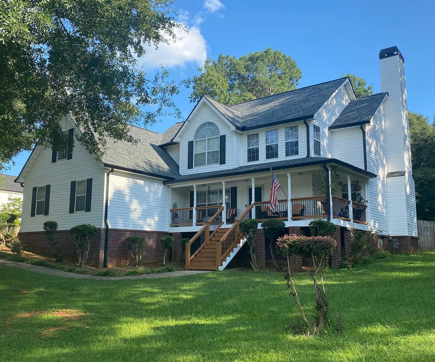 A large white house with a porch and stairs