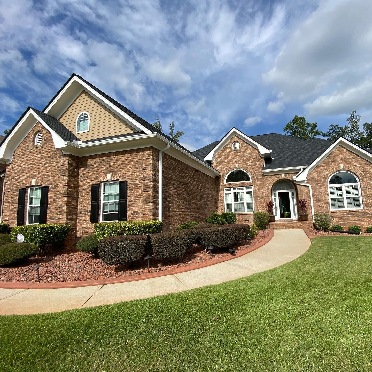 A large brick house with a walkway leading to it