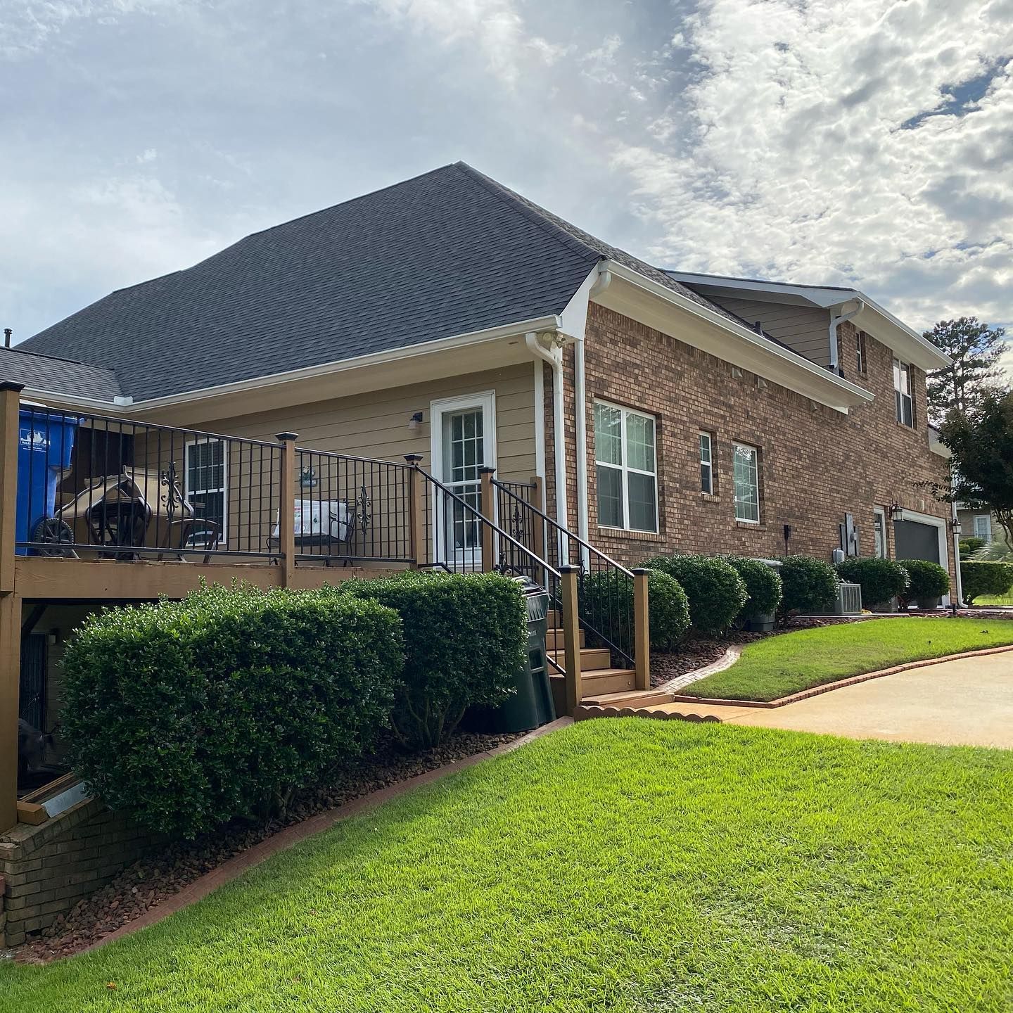 A large brick house with a large deck and stairs